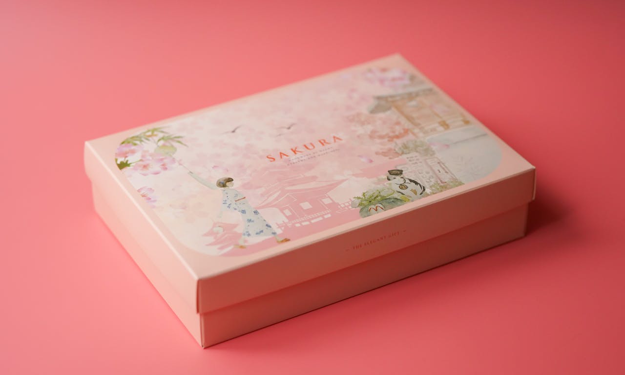 hero-img-01 A beautifully designed Sakura gift box with floral illustrations on a soft pink background.