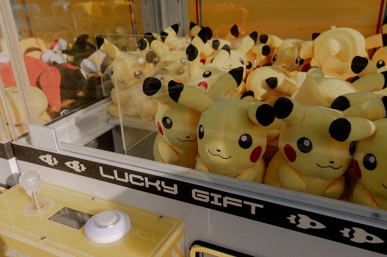 gallery-3 Pikachu plush toys inside an arcade claw machine labeled 'Lucky Gift'.