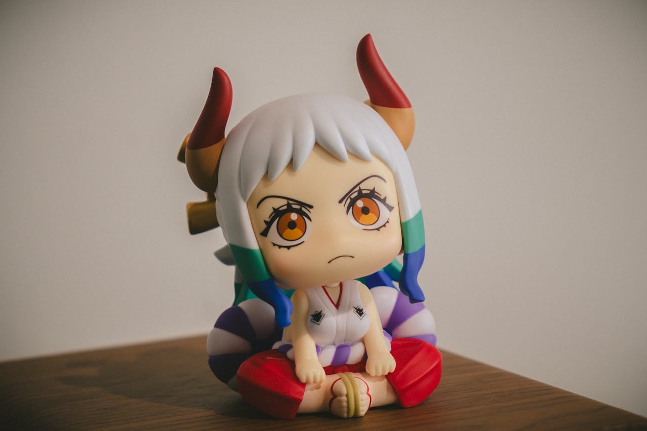 services-04 Close-up of a colorful anime figurine with horns, sitting on a wooden surface.