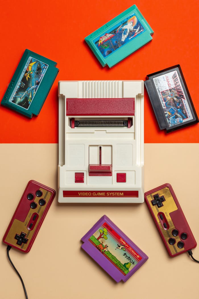 gallery-5 Flat lay of vintage video game console with colorful cartridges on vibrant background.